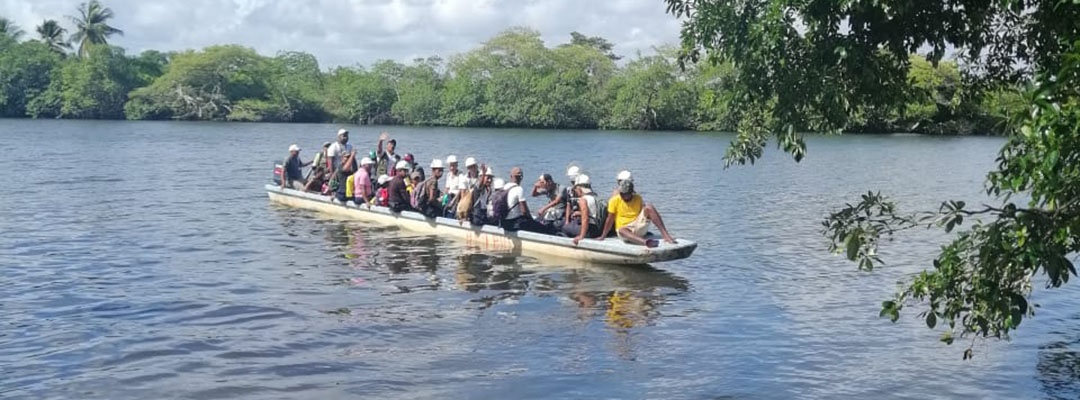malaria workers in a large canoe on the water.