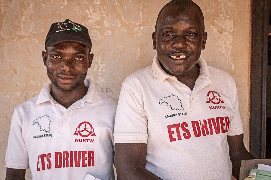 ETS drivers in Kaduna, Nigeria, sport uniforms that include white golf shirts with the words 'ETS driver' in large red lettering across the front.