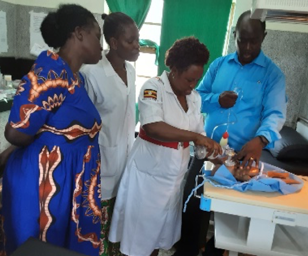 A group of health workers practice resuscitation techniques on a doll.