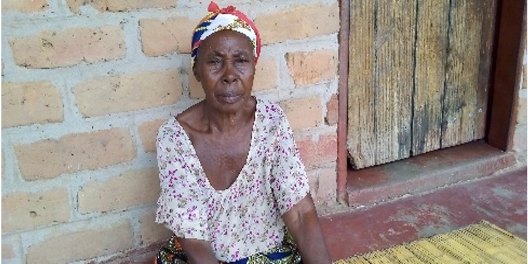 Rhoda sits outside her house after getting her blood pressure checked by a community health assistant