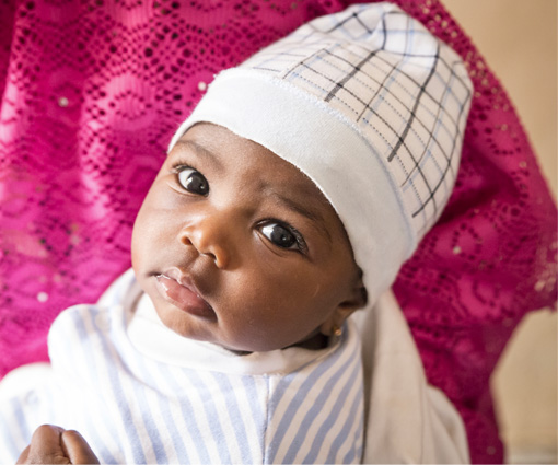 An infant child wearing a white knit cap.